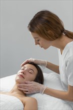 Beautician with female client salon face care routine 5