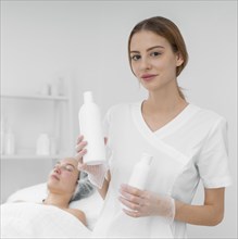 Beautician with lotion female client