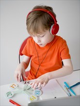 Child wearing headphones e learning concept