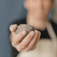 Close up blurry man holding clay