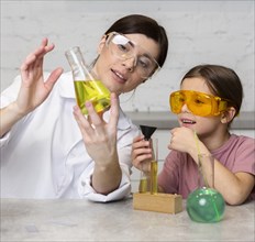 Female teacher girl doing science experiments with test tubes