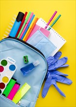 Flat lay school essentials with gloves backpack