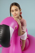 Girl sitting inflatable flamingo