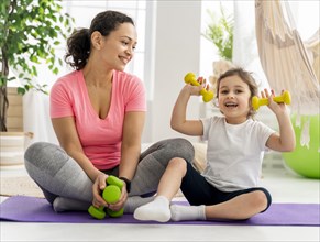 Kid woman training with dumbbells