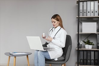 Medium shot doctor sitting with computer