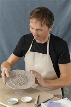 Medium shot smiley man doing pottery