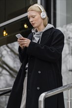 Medium shot woman holding smartphone 3