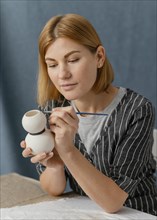 Medium shot woman painting pottery item