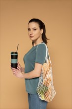 Side view woman with turtle bag thermos
