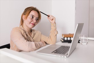 Smiley female teacher using laptop during online class