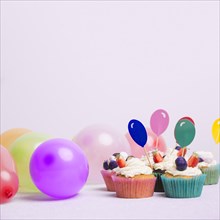 Small cupcakes with air balloons white table