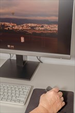 Woman's hand working at her computer with an ergonomic vertical computer mouse to avoid hand pains