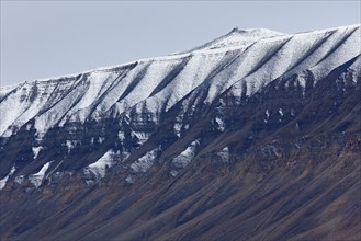 Snow covered eroded mountain slope at Adventdalen