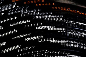 Blurred black computer keyboard with illuminated backlit white keys