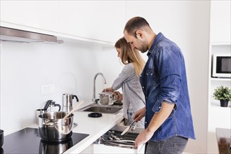 Young couple working with utensils kitchen