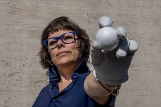 Golfer with a Glove Holding Up Her Golf Ball in a Sunny Day in Switzerland