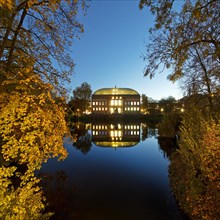 The Staendehaus K21 is reflected in the Kaiserteich in autumn in the evening