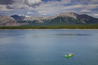 Family in green canoe with father fishing in Lower Kananaskis Lake