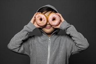 Medium shot kid holding doughnuts