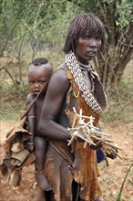 Woman of the Hamar tribe carrying child on her back