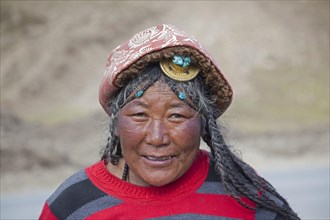 Portrait of Tibetan Khampa woman wearing traditional amber hair piece at Zhuqing