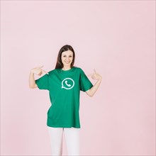 Portrait smiling woman pointing her t shirt with whatsapp icon
