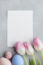 Top view blank paper with tulips colorful easter eggs