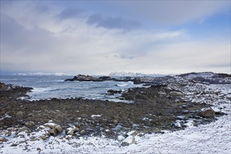Rocky beach along the coast in the snow in winter