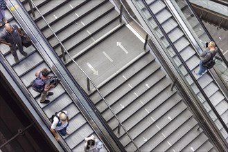 Escalator and stairs and railway travellers