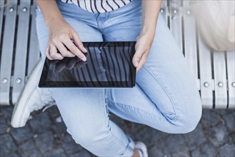 Elevated view woman touching digital tablet screen