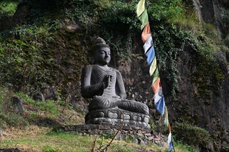 Buddha statue and Tibetan prayer flags in front of the entrance to the Messner Mountain Museum near Bolzano