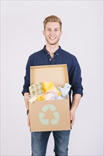 Portrait man holding cardboard box full garbage with recycle icon