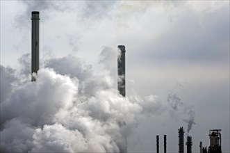 Conceptual image showing air pollution from petrochemical industry showing chimneys encompassed with smoke