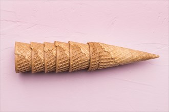 Stacked waffle cones pink background