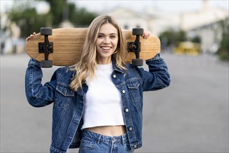 Medium shot woman holding skateboard