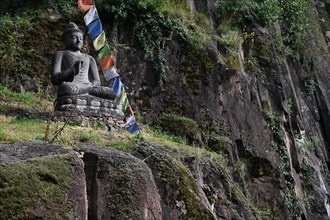 Buddha statue and Tibetan prayer flags in front of the entrance to the Messner Mountain Museum near Bolzano