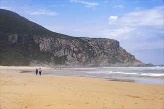 Tourists walking on Nature's Valley sandy beach in the Tsitsikamma Section of the Garden Route National Park