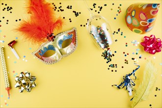 Top view carnival mask with decoration material yellow background