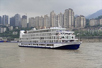 Cruise ship on the Yangtze River against a backdrop of skyscrapers