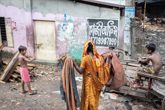 Woman with washed clothes and two boys