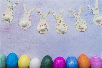 Ornamental paper rabbits twist near easter eggs
