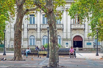 Locals resting on benches in front of the Ateneo de Montevideo at the Plaza de Cagancha in the barrio Centro at Montevideo