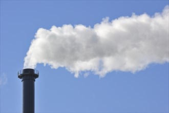 Conceptual image showing air pollution from industry showing chimney issuing fume into the atmosphere