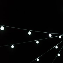 White christmas incandescent light bulb decoration against black backdrop