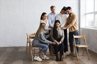Woman being consoled by people group therapy session