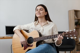 Smiley female musician playing acoustic guitar
