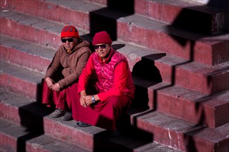 Two monks sitting on the stairs to Karzok monastery