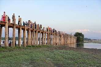 Locals and tourists on a teak bridge