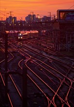 Elevated view of many tracks with a local train at sunset