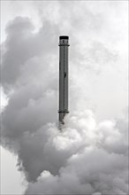 Conceptual image showing air pollution from petrochemical industry showing chimney encompassed with smoke